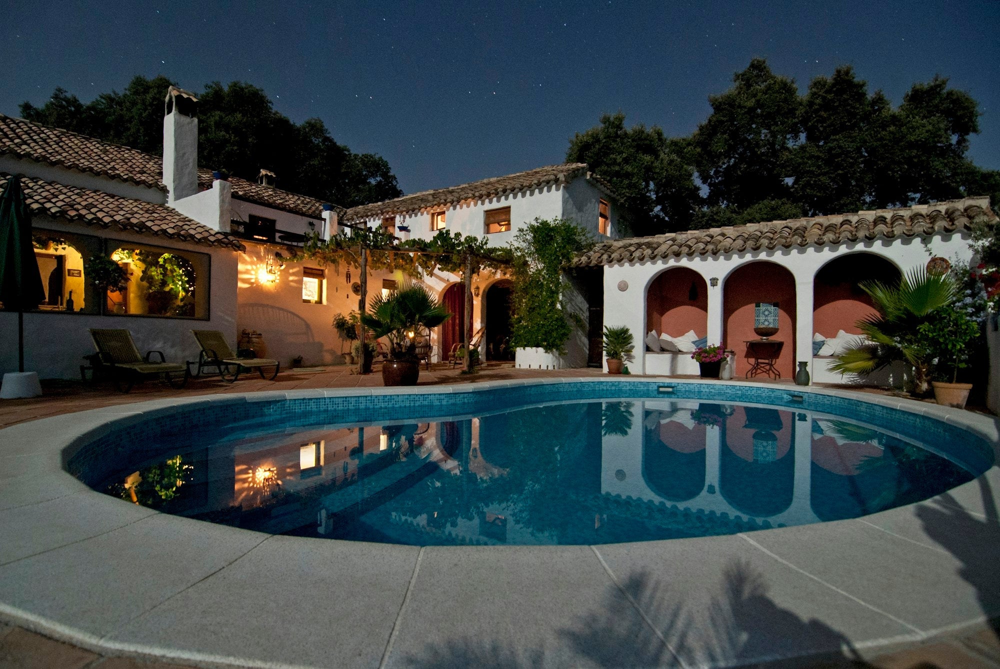 Mediterranean villa terrace with a pool at dusk