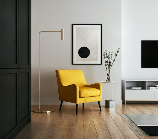 Styled interior with an armchair, floor lamp and framed art